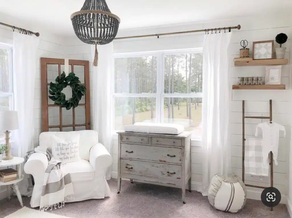 Farmhouse gender-neutral nursery with rustic dresser and soft sheer curtains