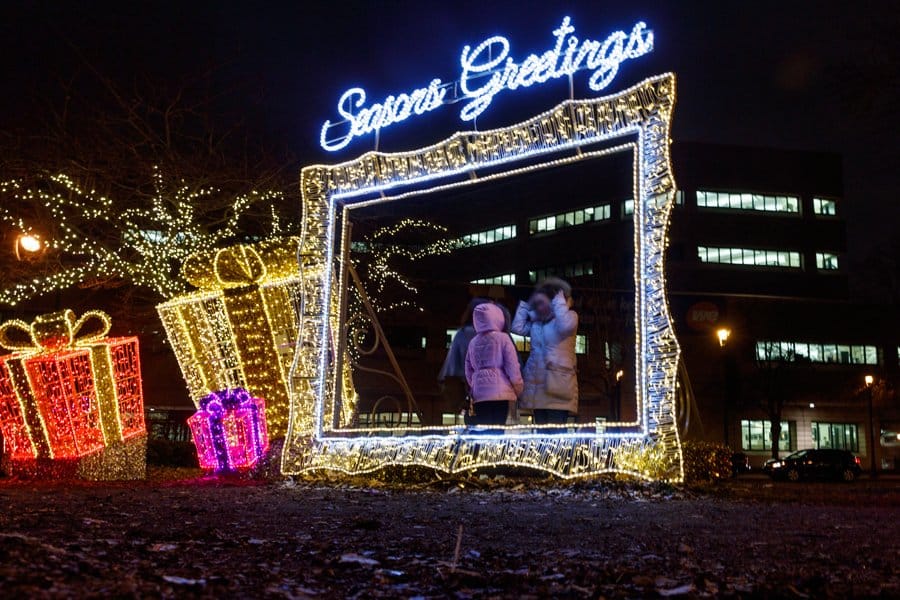 Families taking a photo in one of the glowing LED photo op display at Milwaukee's annual Holiday Lights Festival.