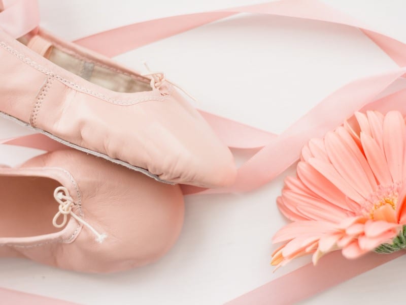 A pair of ballerina shoes and a pink daisy to symbolize pretty and elegant French girl names