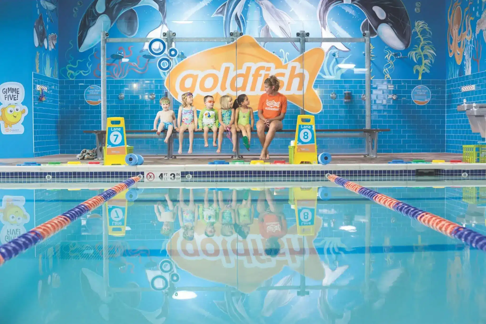 A coach talking to five children about swimming at the Goldfish Swim School in Milwaukee