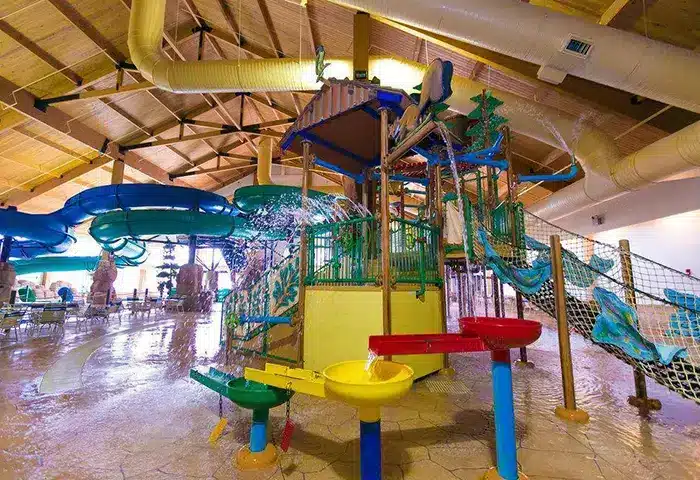 Kids playing under giant dump bucket at Tundra Lodge water park in Green Bay