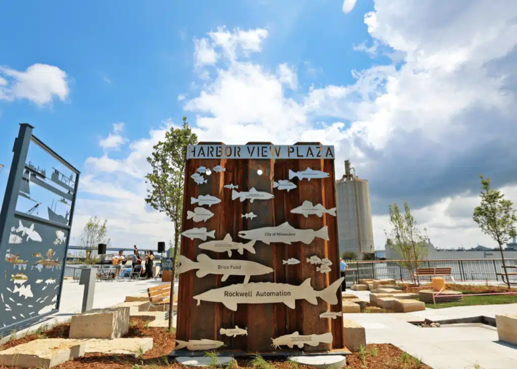 Harbor View Plaza sign with fish sculptures overlooking Milwaukee’s waterfront.