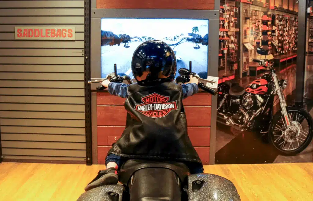 Toddler with a Harley Davidson leather vest on a motorcycle 