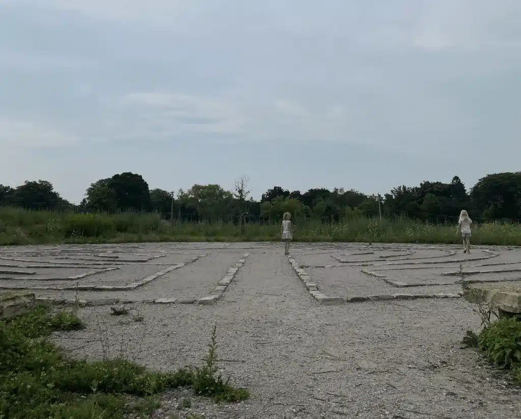 Two young girls play on the stone labyrinth in Hartung Park in Wauwatosa.