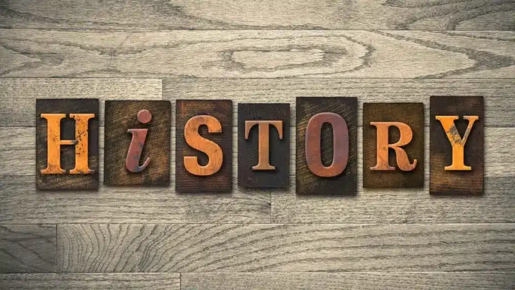 Wooden letter blocks spelling HISTORY on a wooden background.