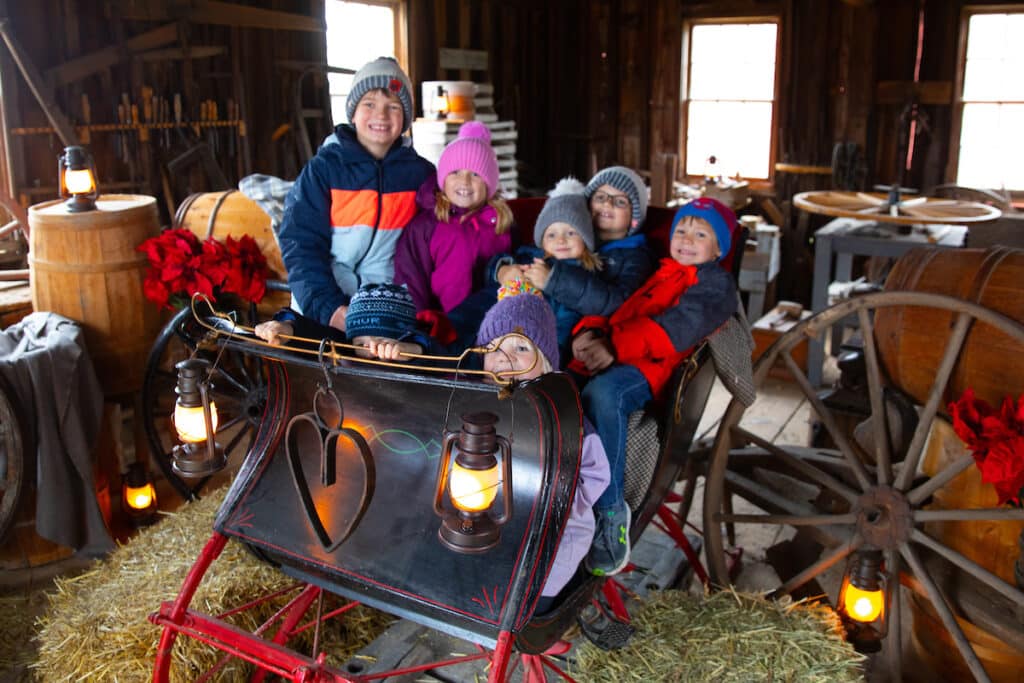 Kids sitting on a sleigh at the Home for the Holidays event in Old World Wisconsin
