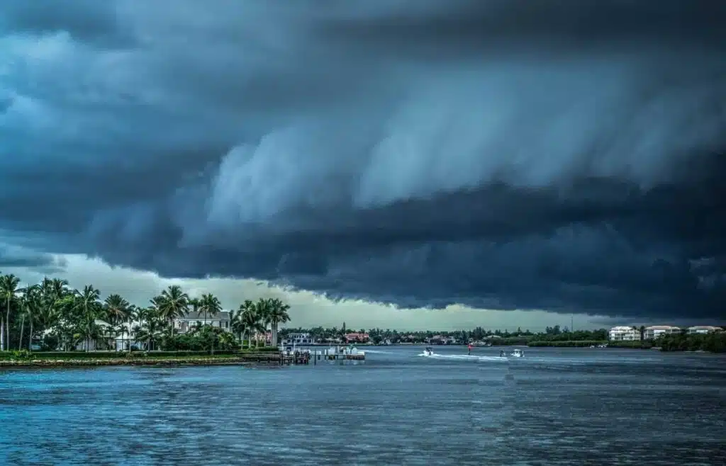 Dark storm clouds rolling toward coastal homes before a hurricane hits.
