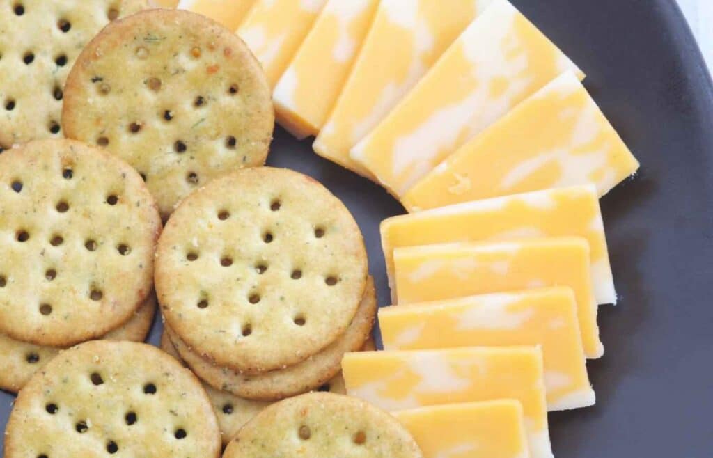Round crackers with slices of cheddar cheese