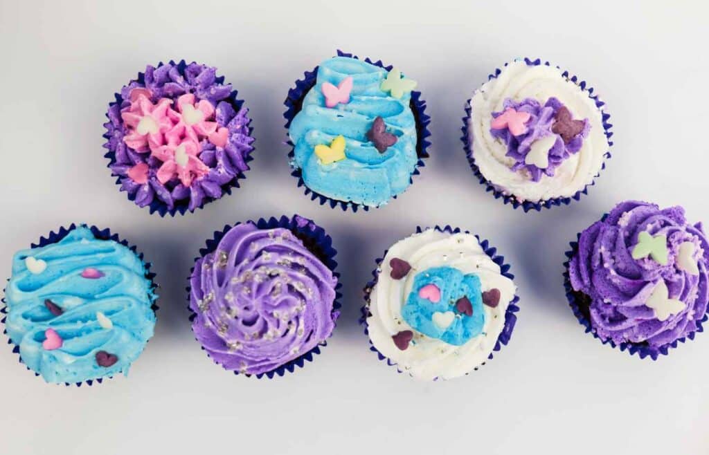 Cupcakes in blue, white and violet icing to be served at a birthday celebration