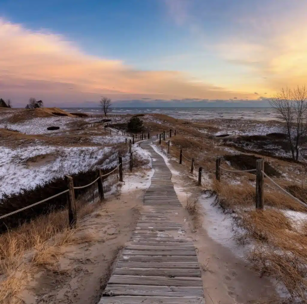 A wooden board walk leading to a sandy beach