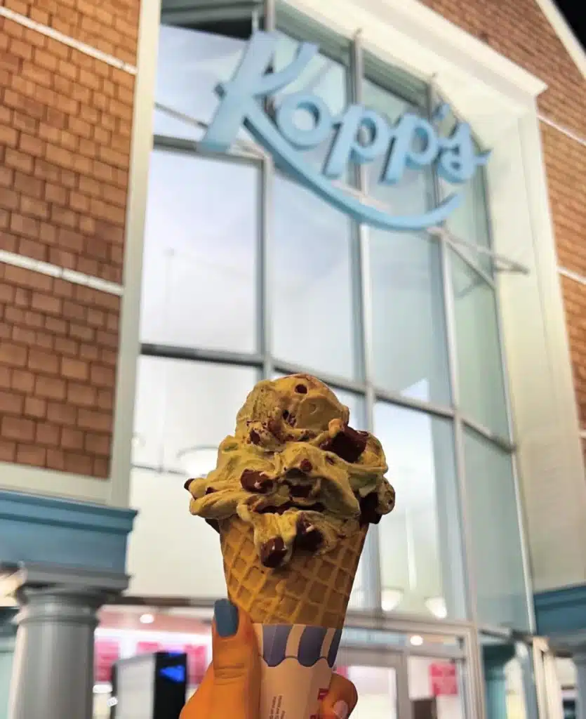 Freshly scopped ice cream held in front of Kopps Frozen Custard in Glendale