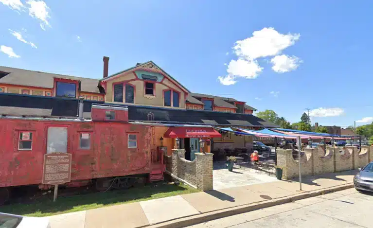 An old red train that serves as the entrance to La Estacion in Waukesha