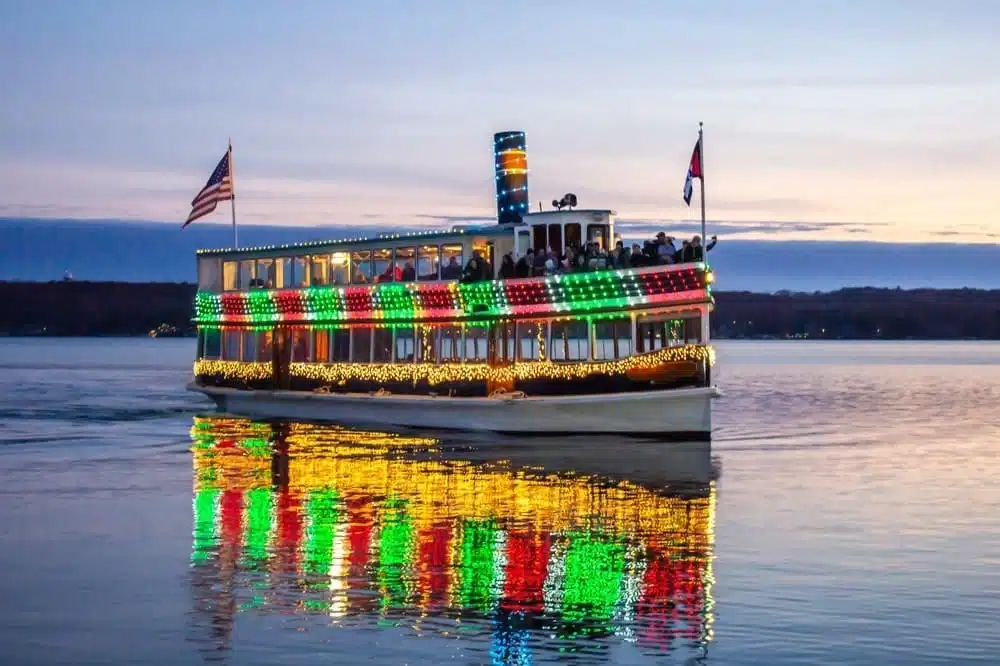 Boat with tourists cruising on the lake with two flags and LED displays.