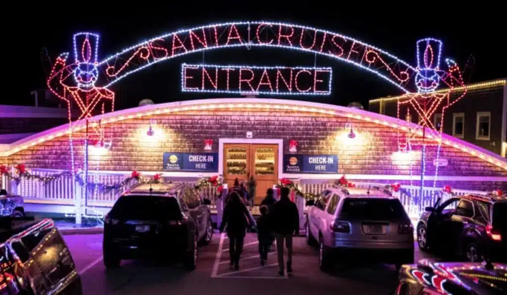 The check-in or entrance to the Santa Cruise with parked cars and Christmas lights