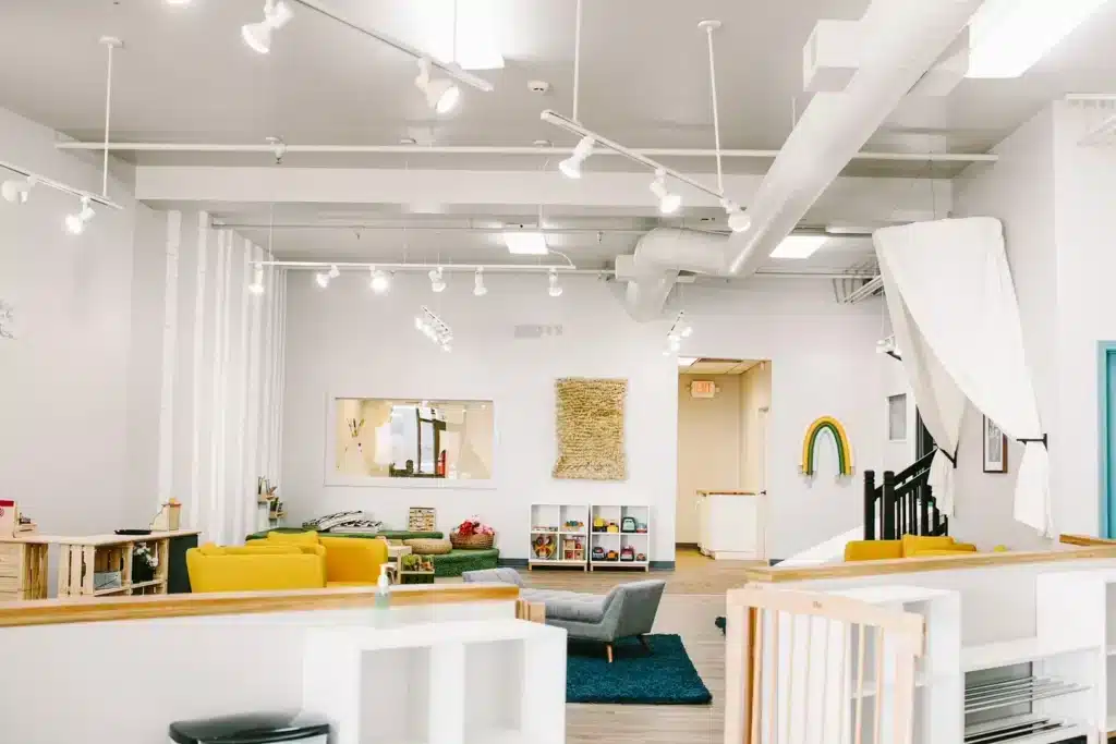 Vibrant interiors of Little Sprouts Play Cafe in Shorewood with yellow couches and white walls.