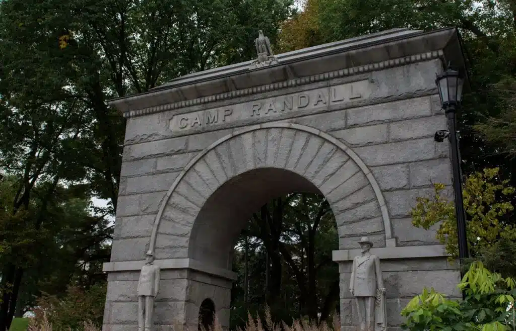 Historic Camp Randall stone archway surrounded by trees in Madison.