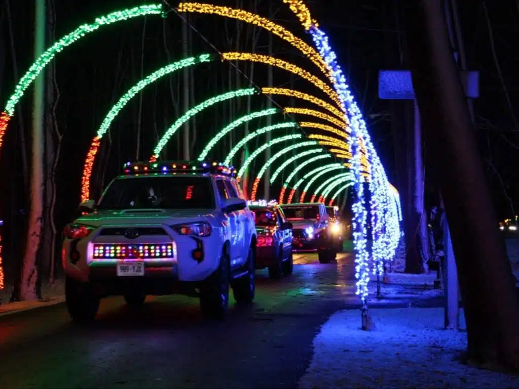 Cars driving under colorful arches in the Making Spirits Bright light show in Sheboygan Wisconsin