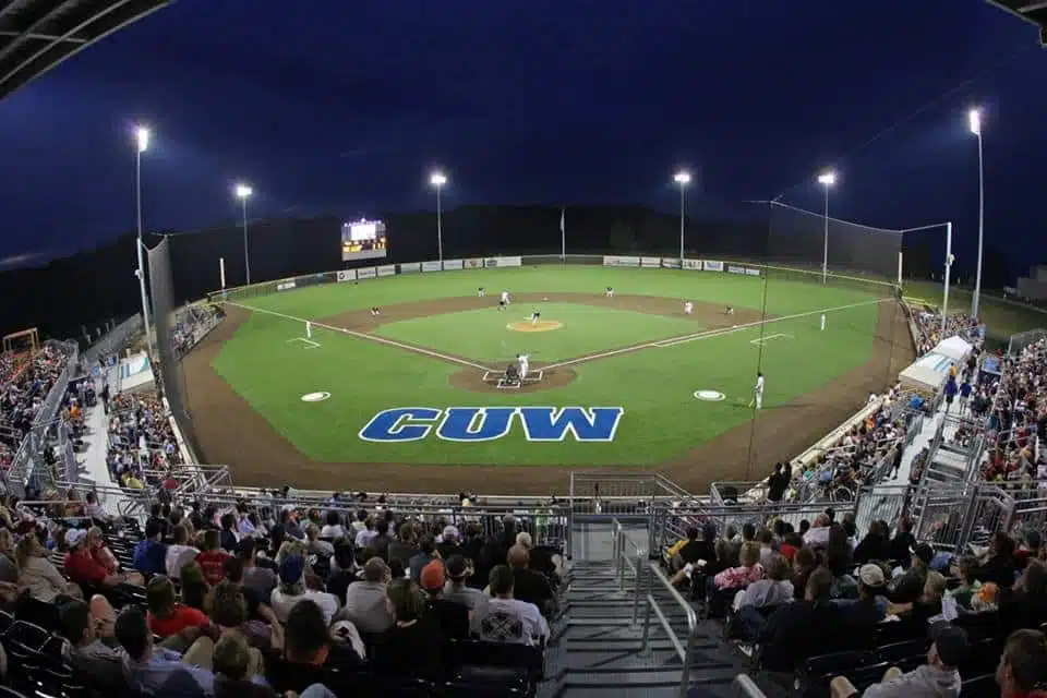 Nighttime baseball game at Kapco Park with fans filling the stadium.