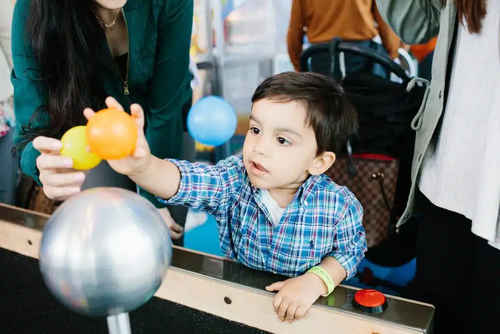 Toddler exploring a hands-on science exhibit at Discovery World in Milwaukee.