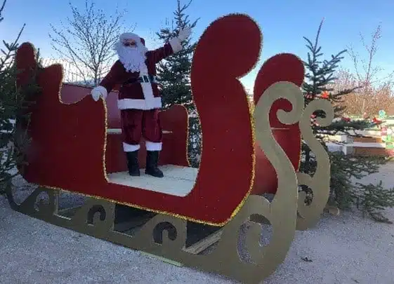 Santa riding a giant red sleigh at the Candy Cane Express at Apple Holler