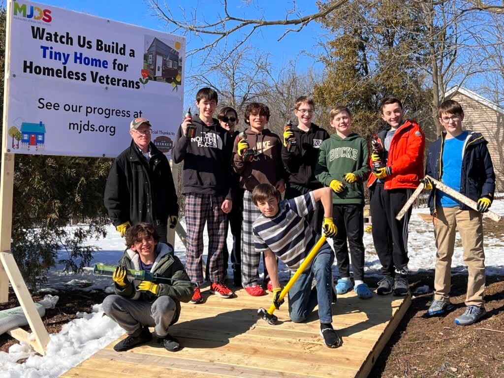 Teenage boys and their instructor building a tiny home
