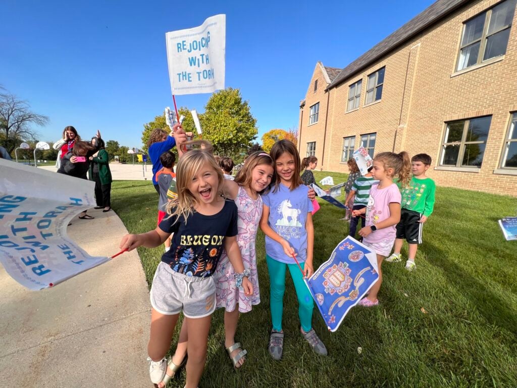 Kids in front of Milwaukee Jewish Day School holding banners
