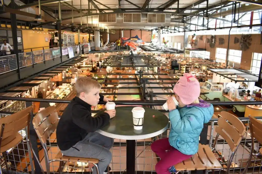 Two kids sippping hot drinks at Milwaukee Public market