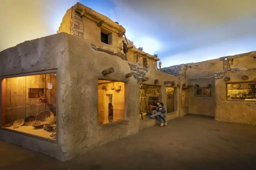 Mother and son sitting a the door of a pueblo in the Soutwest Desert exhibit
