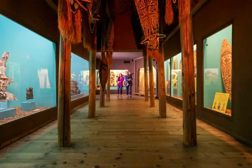A family walking through the halls of Milwaukee Public Museum decorated with Polynesian artwork