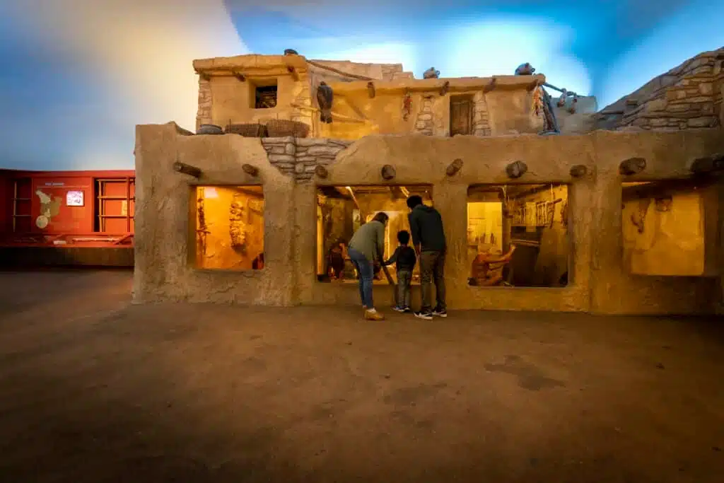Family of three checks out the traditional home of the Hopi people at the Milwaukee Public Museum