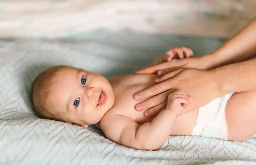 Two month old baby smiling during supervised tummy time on soft blanket