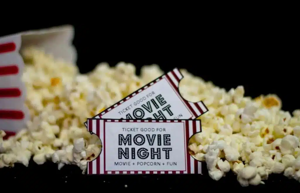 Box of popcorn with 2 movie tickets