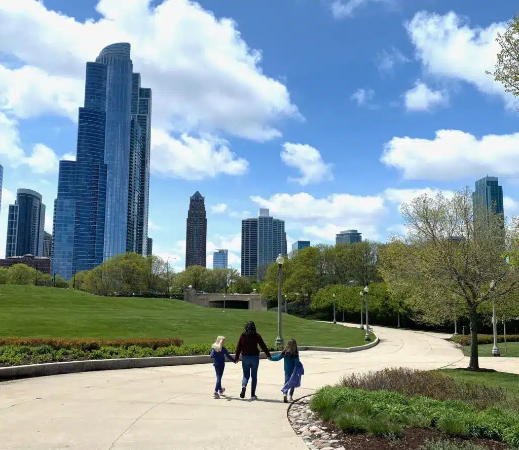 A family walks along a sunny, tree-lined path at Chicago’s Museum Campus.