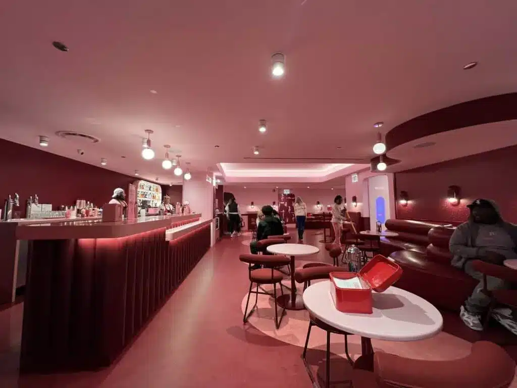 Pink lounge with modern seating and a bar inside the Museum of Ice Cream.
