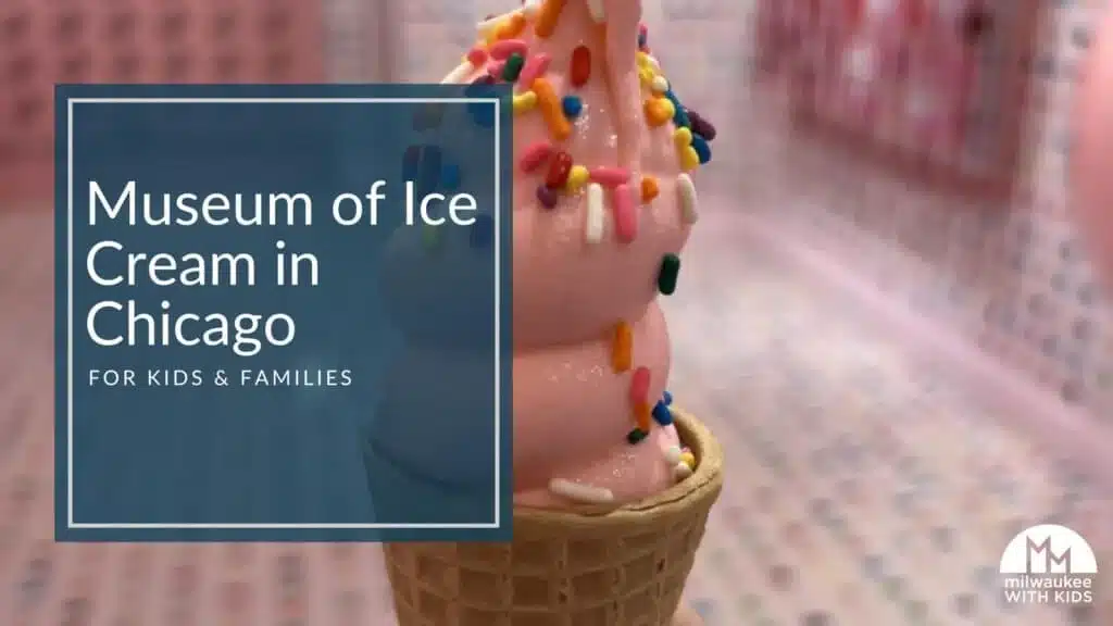 Pink soft-serve ice cream with rainbow sprinkles in a waffle cone.