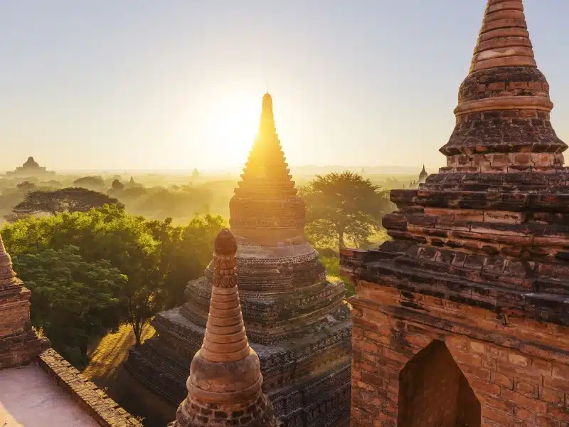 Ancient stone temple surrounded by golden morning light.