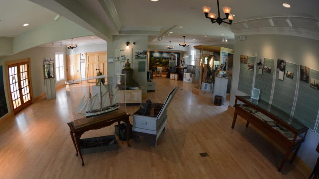 Displays of sailboat scale model, bell and images at North Point Lighthouse and Museum at Lake Park, Milwaukee