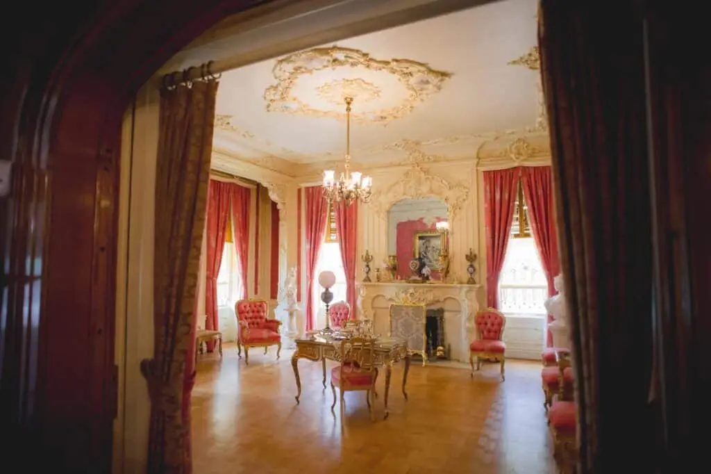 One of the rooms at Pabst Mansion in Milwaukee with coral colored furniture and curtains
