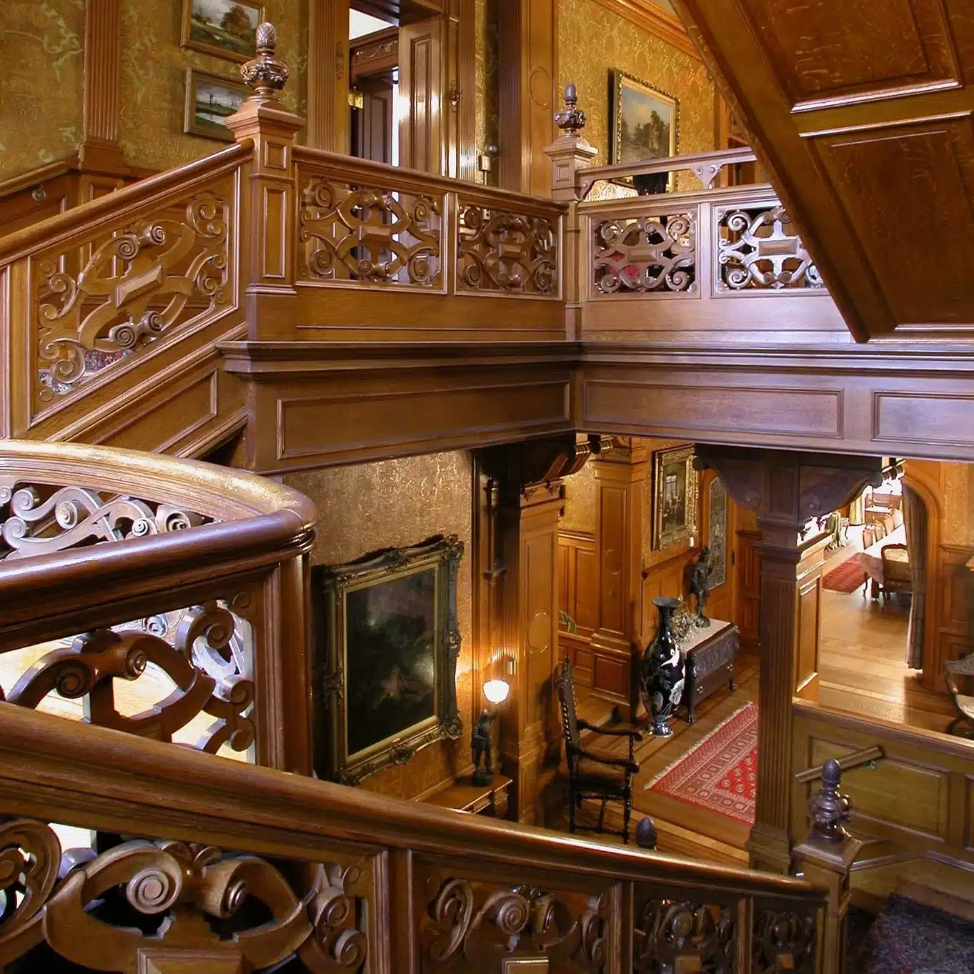 Wooden staricase with intricate details with view of some rooms in the Pabst Mansion