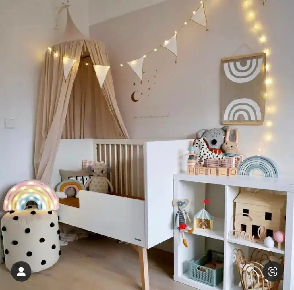 Rainbow gender-neutral nursery with soft lights, neutral crib and string lights
