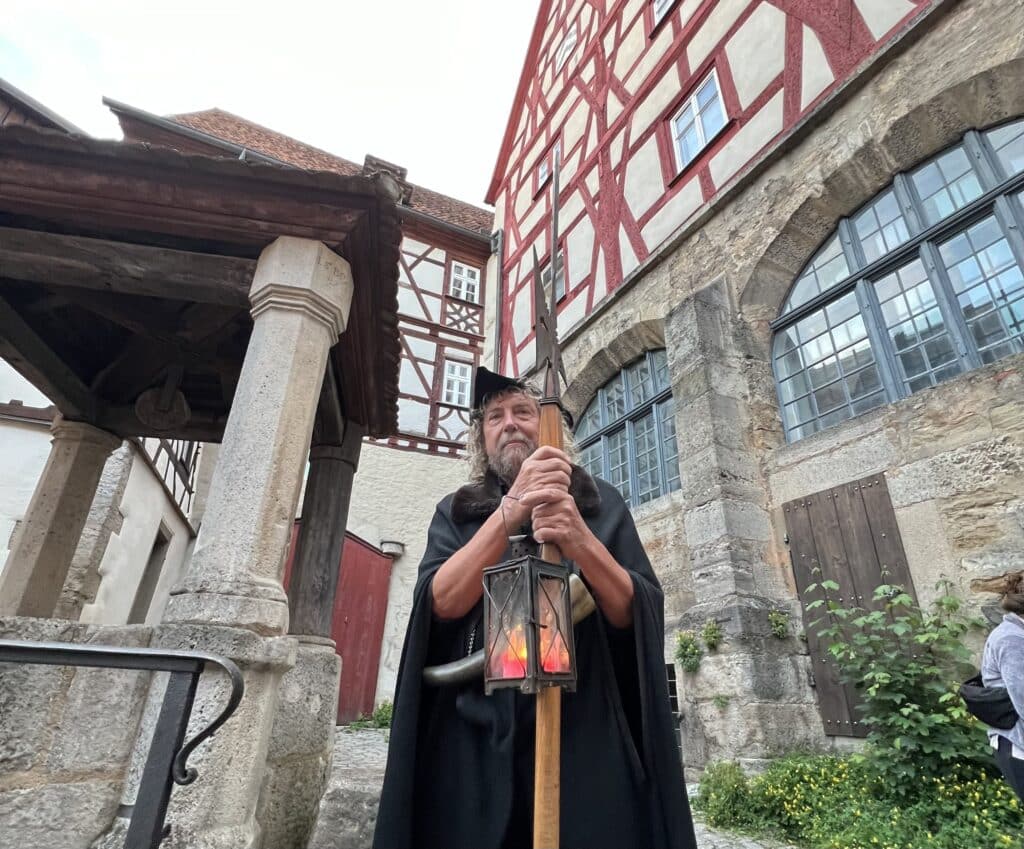 Man dressed a a night watch man during a historical tour at Rothenburg