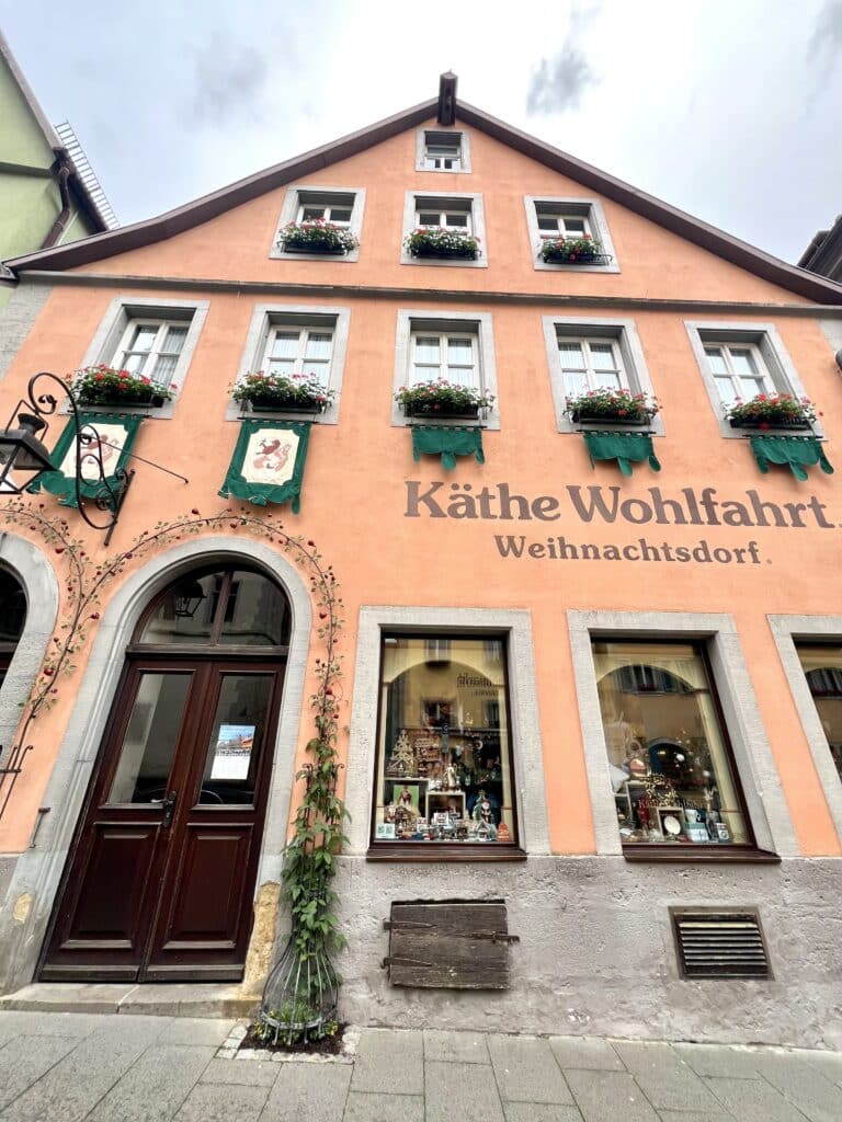 The shopfront of Kathe Wohlfahrt Christmas Store with window banners and flower pots
