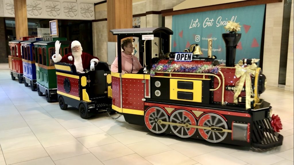 Santa riding a train and waving to passers-by at Southridge Mall in Glendale