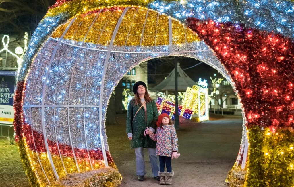 A family looking at large holiday installations at Zeidler Union Square