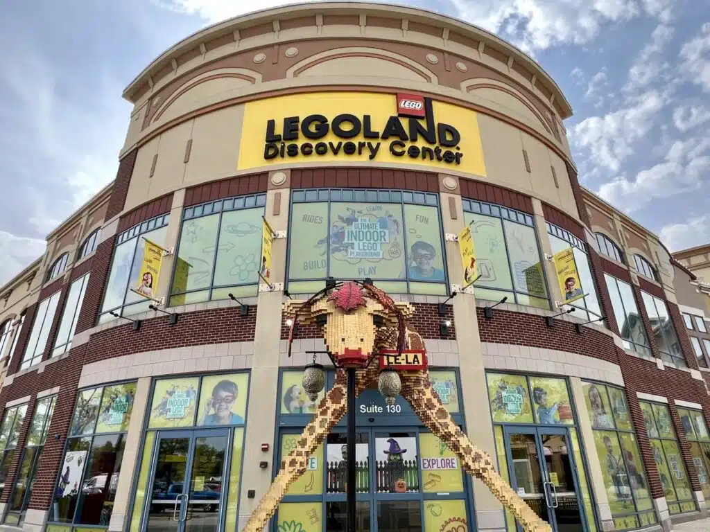 Exterior entrance of LEGO Discovery Center Schaumburg with giant LEGO giraffe sculpture.