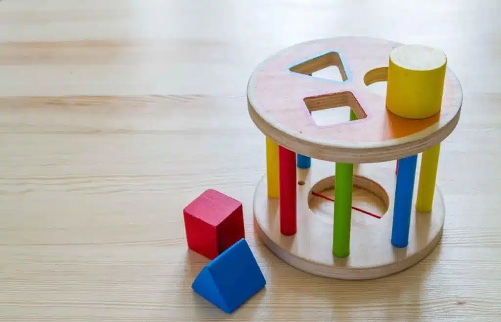 Wooden shape sorter toy with colorful geometric blocks.