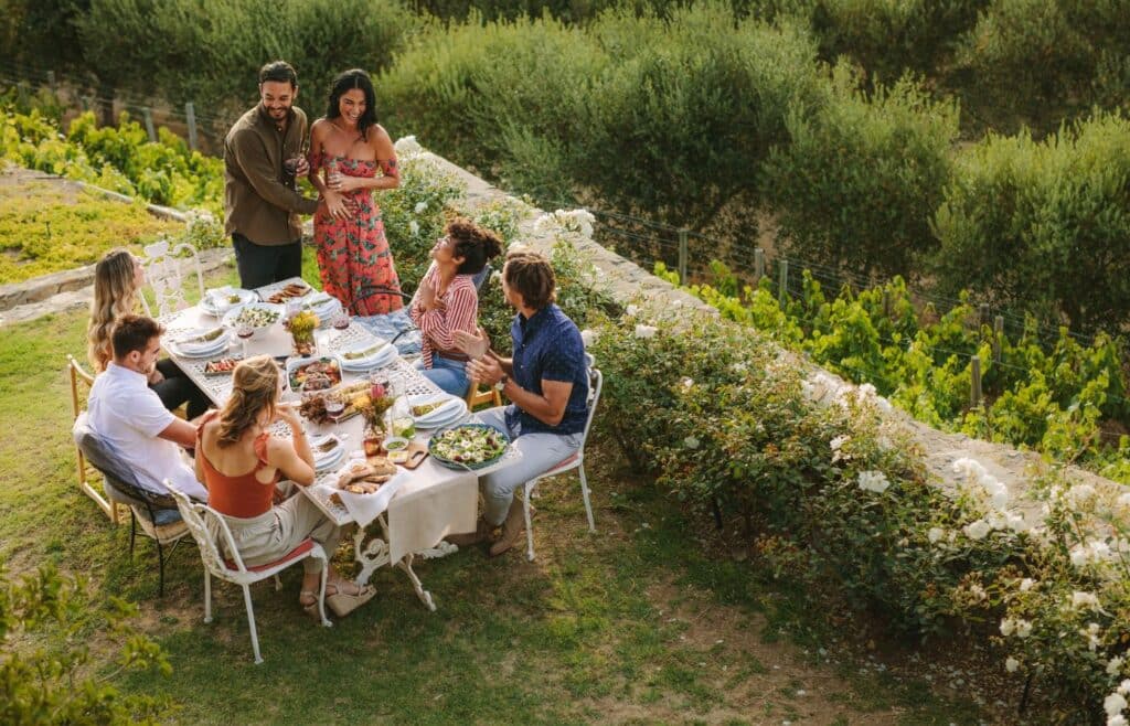 A couple sharing pregnancy news to friends over a garden party