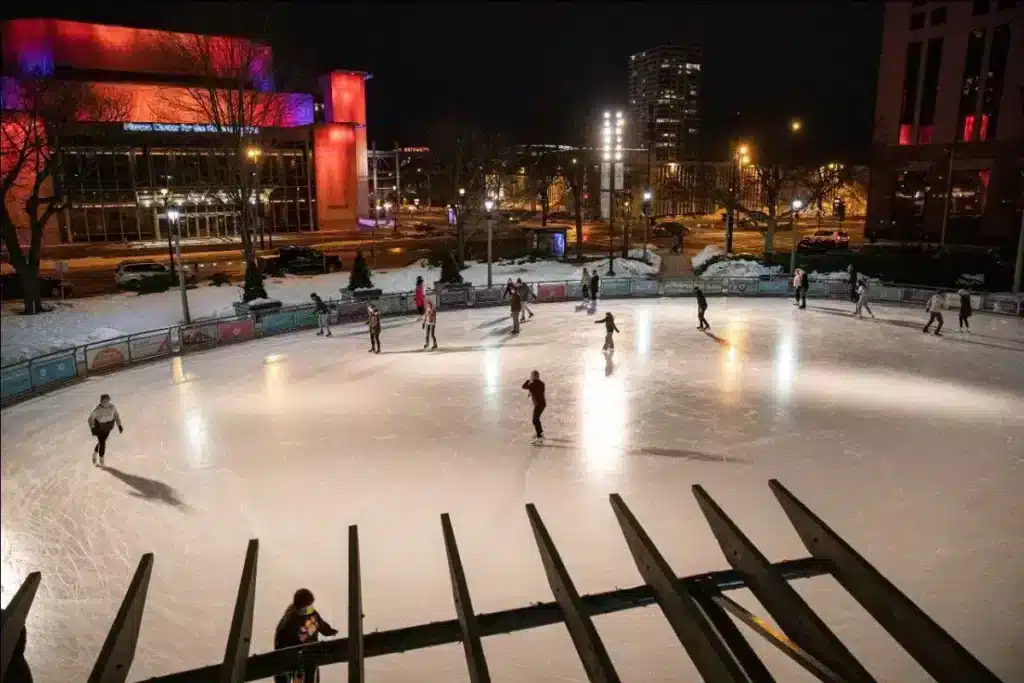 People enjoying ice skating at the Red Arrow Park during the Slice of Ice Lights event