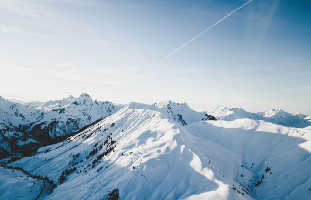 Snow covering the top of the mountains with trees seen from afar - winter trivia for kids