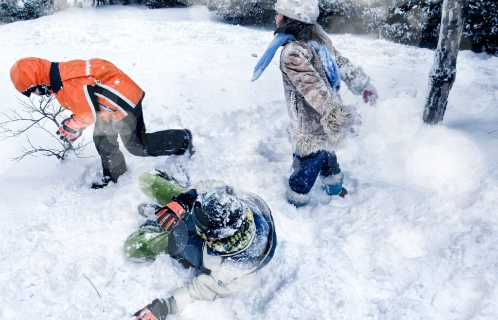 Three kids playing in the snow - fun facts about snow for kids